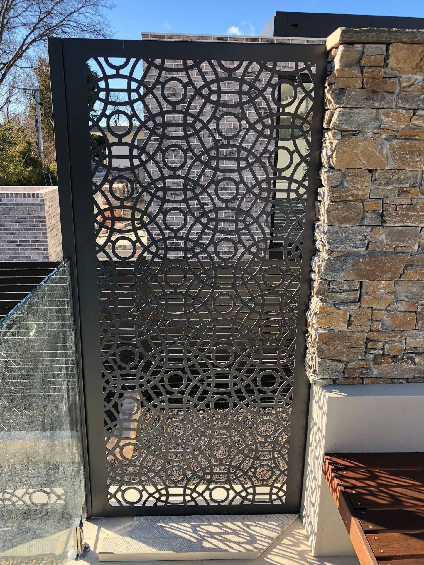 Powder-coated steel privacy screen with laser-cut decorative pattern, providing outdoor privacy and a contemporary design feature for gardens and patios.