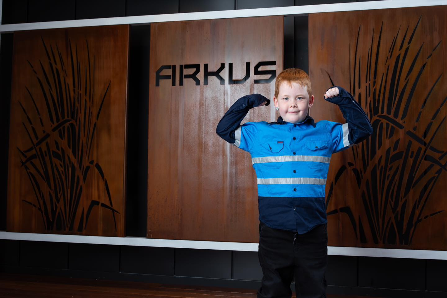 Hi-vis shirt flex pose in front of Arkus decorative screen showcase