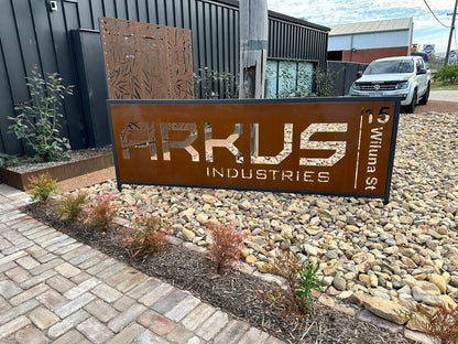 Corten steel business sign with precision laser-cut lettering, featuring a rusted patina finish for a modern, industrial look.